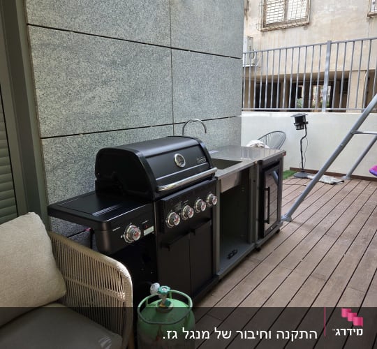 גריל גז ומיכל גז במרפסת עץ